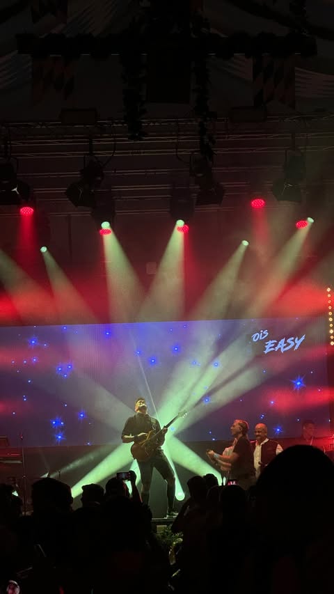 OisEasy live: musicians in front of an LED wall with red and warm white beams of light